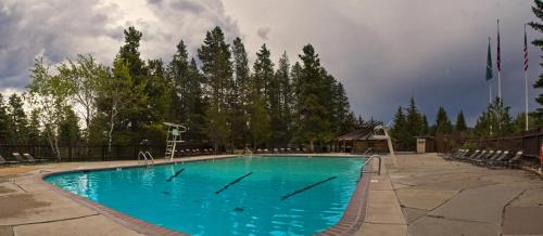 莫兰杰克逊湖旅馆的一个带椅子和树木的大型蓝色游泳池