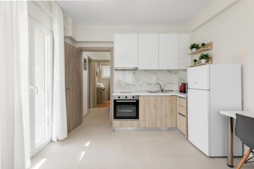 希维利V Luxury Apartments Siviri II的厨房配有白色橱柜和白色冰箱。