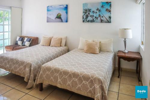 马萨特兰Departamento en Mazatlan con acceso a la playa y alberca común #138的一间卧室配有两张床和椅子