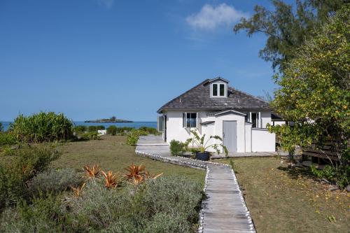 总督港Chez Cay Cottage cottage的白色的房子,有一条通往房子的路径