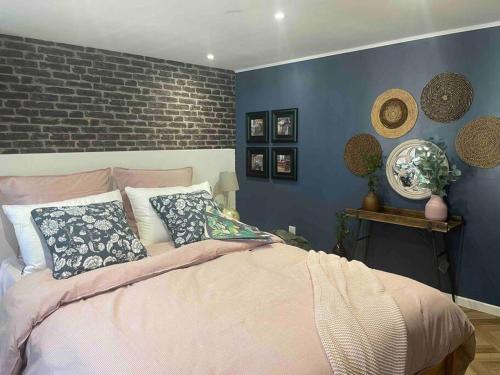 瑞米耶日la planque d'hugo的一间卧室拥有蓝色的墙壁,配有一张带枕头的床。
