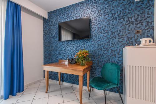 庞特卡格纳诺安科拉酒店的一间设有桌子的房间和蓝色墙壁上的电视