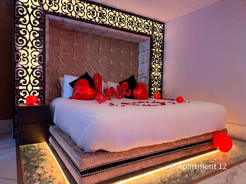 布雷得佛Mansa Apartments的一间卧室配有一张带红色枕头的大床