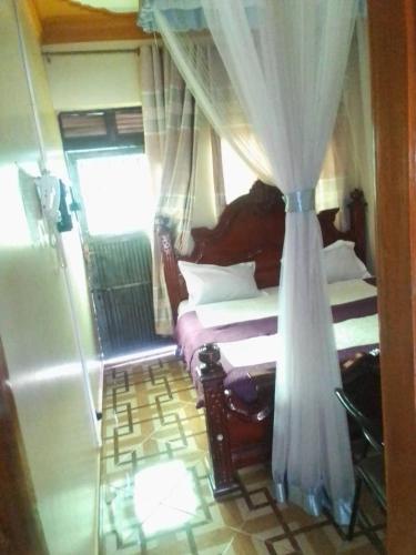 卡巴莱City Max hotel Kabaale的一间卧室配有两张床和窗帘