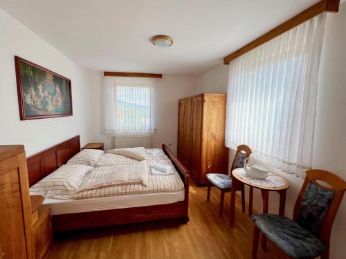 Hrib pri HinjahGuest house Domačija Krnc的卧室配有1张床、1张桌子和1把椅子