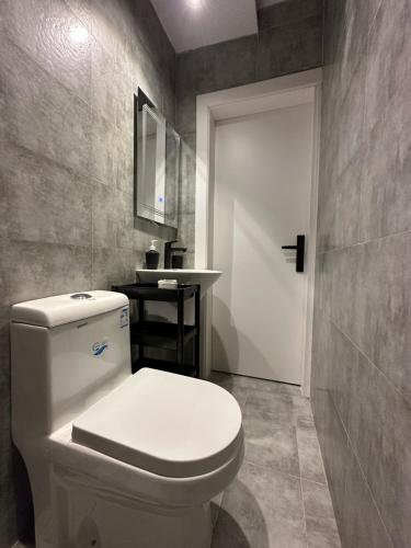 利雅德Villa Apartments的浴室配有白色卫生间和盥洗盆。