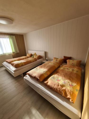 上陶恩Ferienwohnung Jürgen horn的两张床铺位于带墙壁的房间