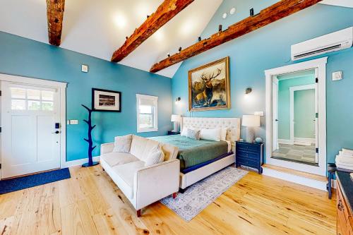 沃特伯里The Lodge - Suite #3的卧室拥有蓝色的墙壁,配有一张床和一张沙发