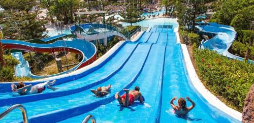福恩吉罗拉Luxury Suites Fuengirola的主题公园的游泳池,人们可以乘坐水上滑梯