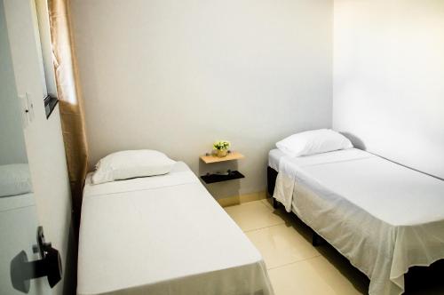帕尔马斯Apartamento novo e completo no Centro de Palmas c/ internet的一间设有两张床和一张小桌子的房间