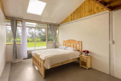 ChaupiIlinizas Mountain Lodge的一间卧室设有一张床和一个窗口