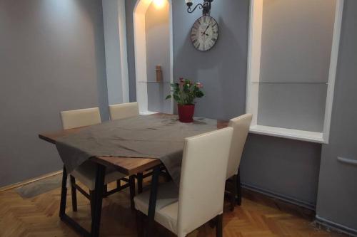 伊斯坦布尔Cozy Apt Nearby Beşiktaş - Keyif ve huzur dolu的餐桌、椅子和墙上的时钟