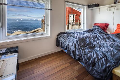 伊卢利萨特Jomsborg Ilulissat的一间卧室配有一张床,享有海景