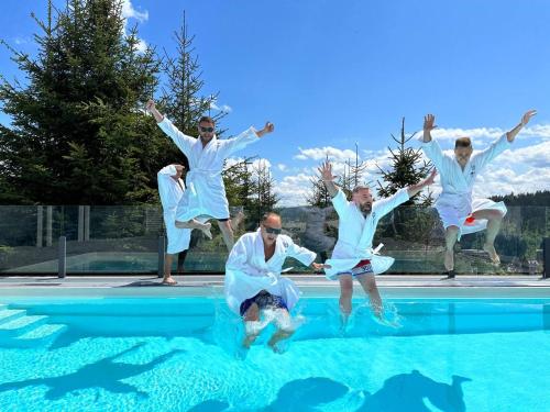 布克维be be Chalet - premium jacuzi & private pool的一群人跳进游泳池