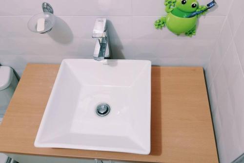 普诺Departamento: Mirador de Puno.的浴室里的一个白色水槽,墙上有青蛙