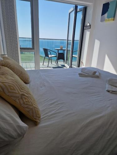纽基Sea View Apartment at One Lusty Glaze的一间卧室设有一张大床,享有海景