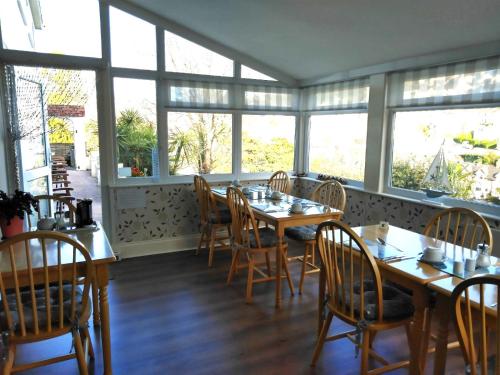 托基Barclay Court Guest House的用餐室设有桌椅和窗户。