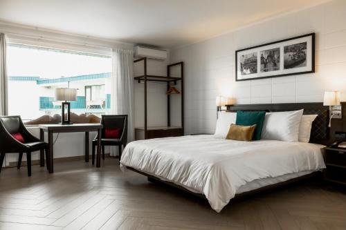 苏瓦Capricorn Hotel Suva的一间卧室配有一张床、一张桌子和一张桌子
