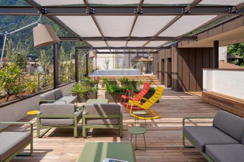 加尔达湖滨贾迪诺威尔第酒店的露台设有五颜六色的椅子和桌子,
