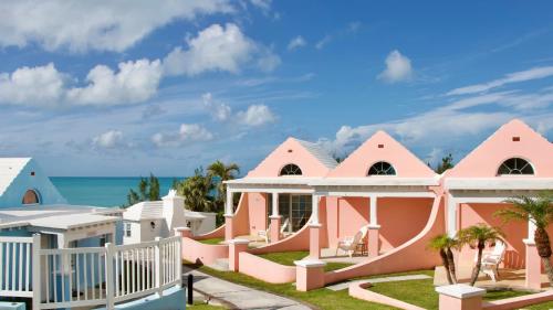 萨默塞特Willowbank Resort的粉红色的房子,背景是大海