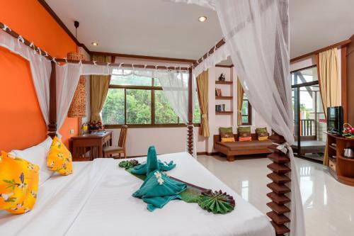 奥南海滩拗喃木屋酒店的一间卧室配有一张橙色墙壁的床