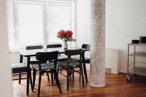 克拉尼Central Apartment Maister的一张带黑色椅子和花瓶的餐桌