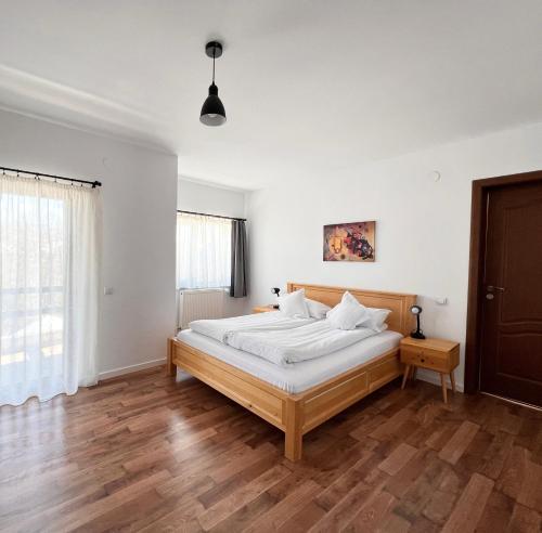 布朗Villa NOVA Cozy and Modern -5 min from center的卧室配有白色墙壁和木地板。