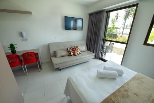 嘎林海斯港MANA BEACH EXPERIENCE by AFT Porto de Galinhas, Muro Alto的客房设有床、沙发和窗户。