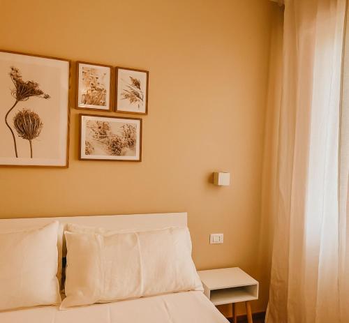 费拉约港Appartamento il Rosmarino的一间卧室配有一张床,墙上挂着一些图片