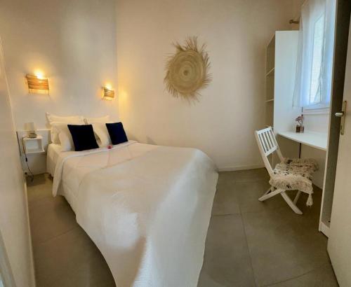 卡尔热斯科伦巴拉公寓式酒店的卧室配有一张白色大床和一把椅子