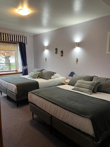 瓦尔迪维亚Montepiedra Costanera Valdivia的一间卧室设有两张床和窗户。