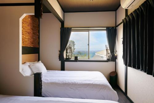 淡路Awaji Aqua Marine Resort Building No, 2 - Vacation STAY 09357v的一间卧室设有两张床和窗户。