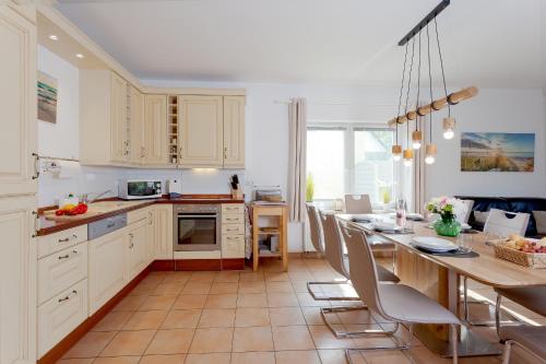 奥斯特西巴德钦诺维茨MEERerholung的厨房配有白色橱柜和桌椅