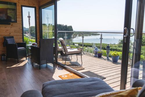 KircubbinHorse Island View Luxury Retreat的门廊上设有屏风,享有海景