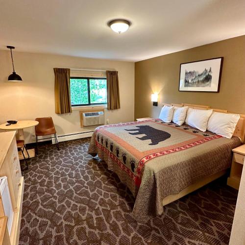 格兰德莱克Spirit Lake Lodge的酒店客房设有一张大床和一张书桌。