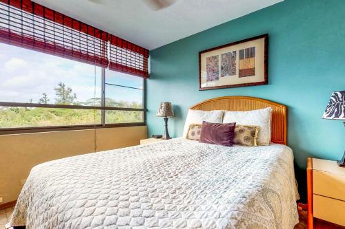 希洛Maunaloa Shores 403的一间卧室设有一张大床和蓝色的墙壁