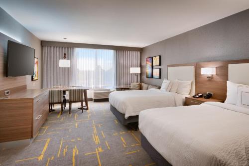 霍桑TownePlace Suites by Marriott Los Angeles LAX/Hawthorne的酒店客房设有两张床和一张桌子