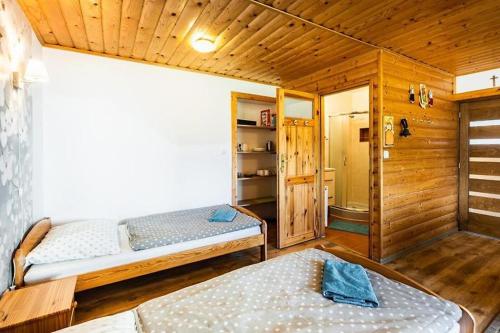 Zubrzyca DolnauKozaków的小木屋内一间卧室,配有两张床