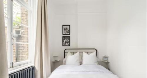 伦敦Spacious 1 bed in Primrose Hill的白色的卧室设有床和窗户