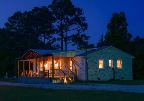 Sneads FerryCarolyn's Lighthouse Topsail Island的夜晚有很多窗户的房子