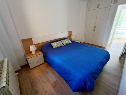 萨莫拉La Casita de Requejo的一间卧室设有蓝色的床,铺有木地板。