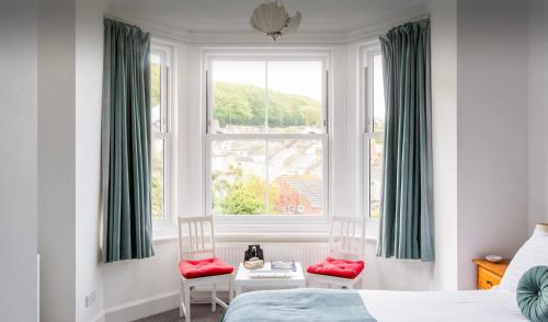 波特兰Brackenbury House的一间卧室配有一张床、两把椅子和一个窗户