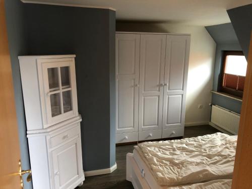 普雷罗ton Timmermanns Hus的一间卧室配有床和白色橱柜