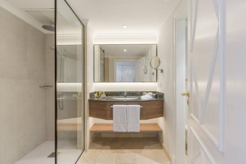 德尼亚Denia Marriott La Sella Golf Resort & Spa的浴室配有盥洗盆和带镜子的淋浴