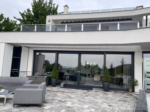 布达厄尔什Luxurious Panorama House with Pool and Sauna的一座带大型玻璃窗和庭院的房子