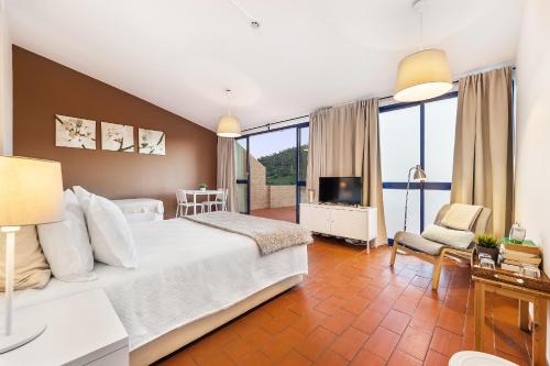 莫托拉贝拉里约酒店的卧室配有一张白色大床和电视。
