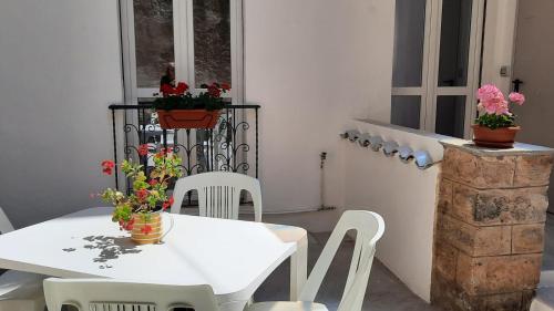 阿尔盖罗La Llua Alghero的阳台上配有白色的桌椅和鲜花