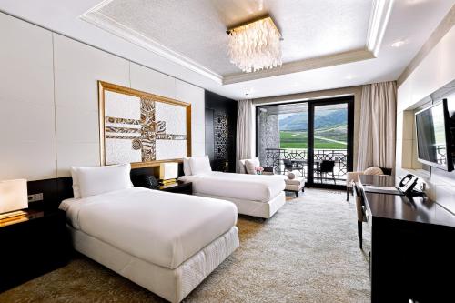 沙达格Shahdag Hotel & Spa的一间带两张床的卧室和一间客厅