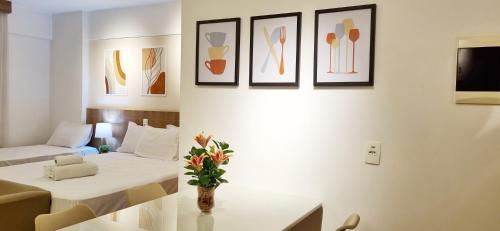 巴西利亚BSB Stay Premium - Flats Particulares - SHN的配有床和鲜花桌的酒店客房