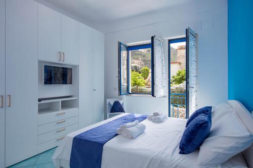 米诺利Casa Sammarco的蓝色和白色的卧室设有床和窗户